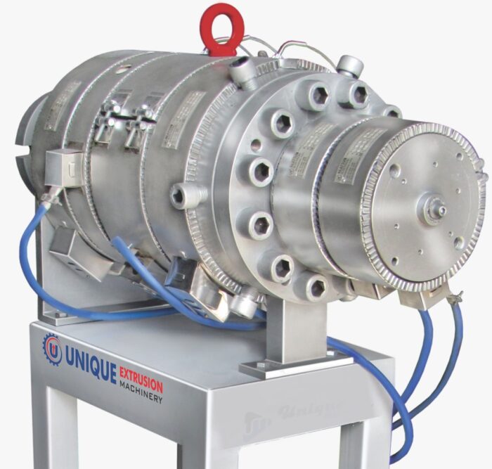 Stainless steel spiral die head on a stand with blue hoses, which forms molten PVC into a pipe shape